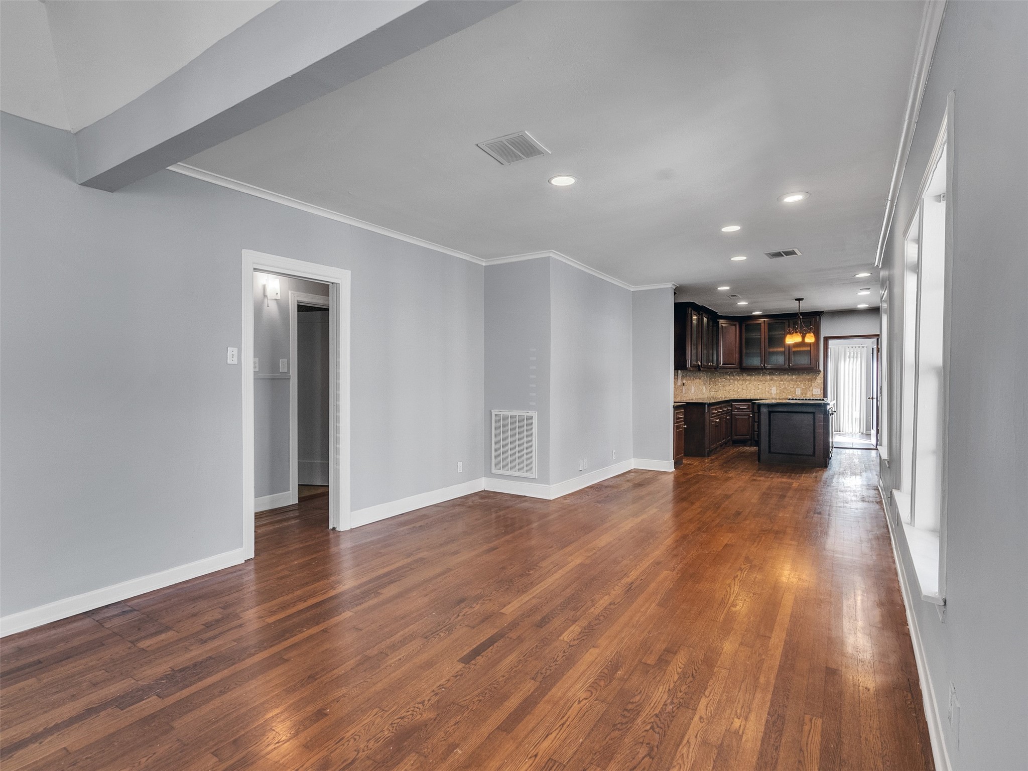 2141 Colquitt Street Houston, TX 77098 - Photo 28 of 50 a view of empty room with wooden floor and kitchen
