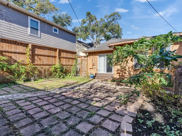a front view of a house with a garden and trees
