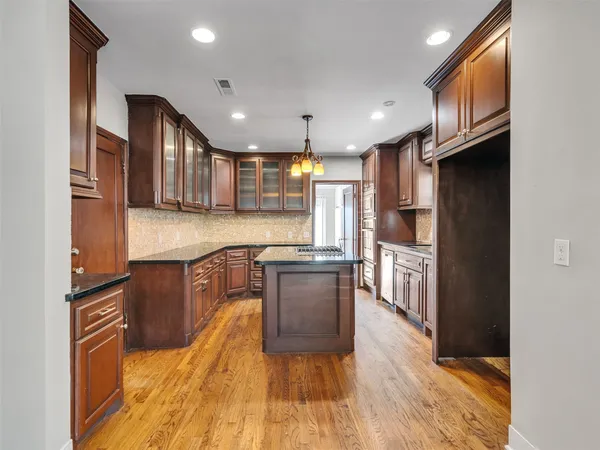 a kitchen with stainless steel appliances granite countertop wooden cabinets a stove top oven a sink and dishwasher