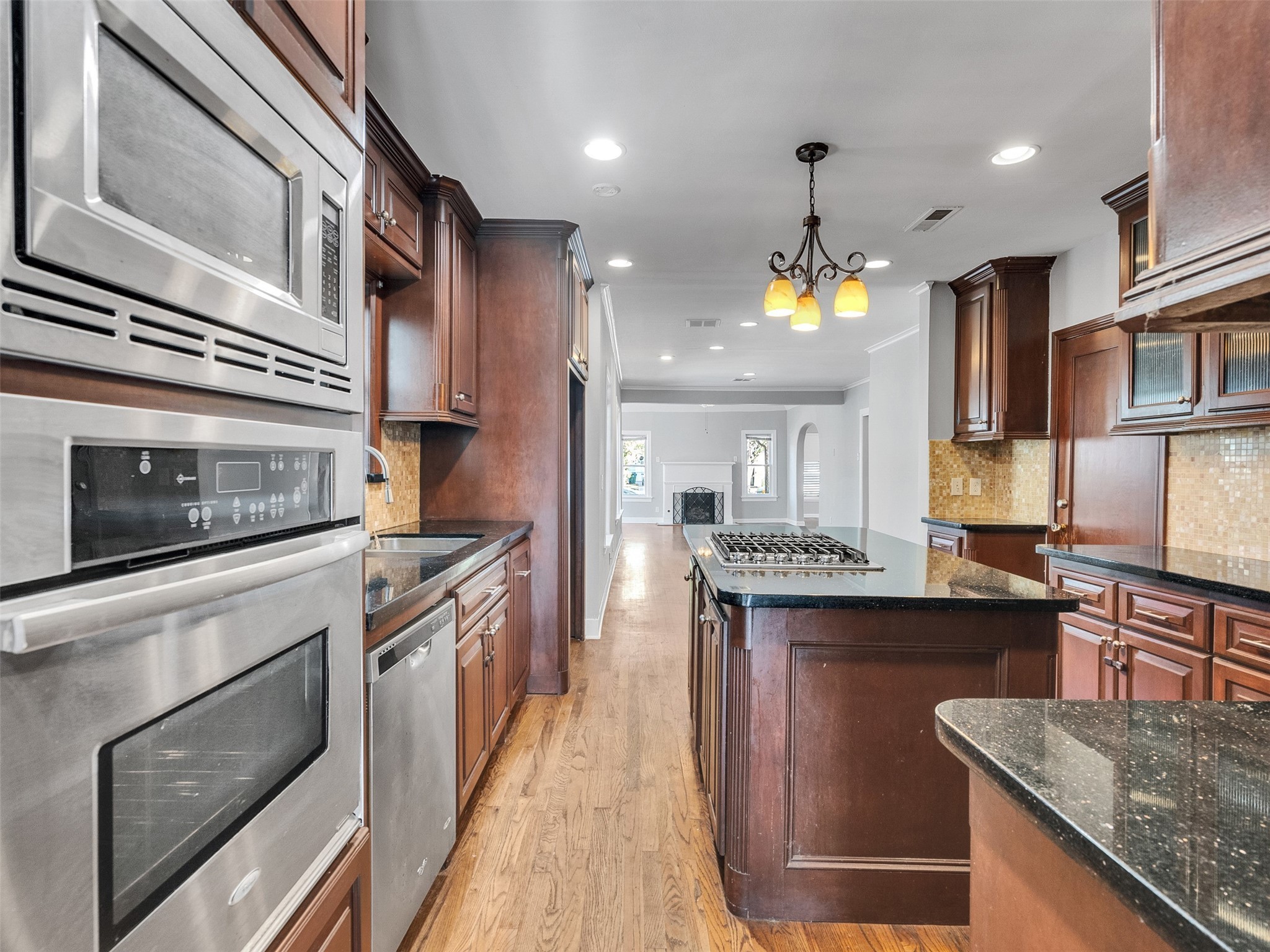 2141 Colquitt Street Houston, TX 77098 - Photo 9 of 50 a kitchen with stainless steel appliances granite countertop a stove top oven a sink dishwasher a dining table and chairs with wooden floor