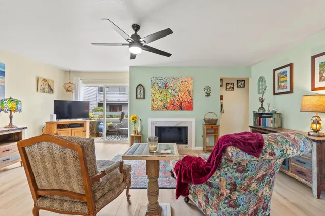 a living room with furniture a flat screen tv and a fireplace