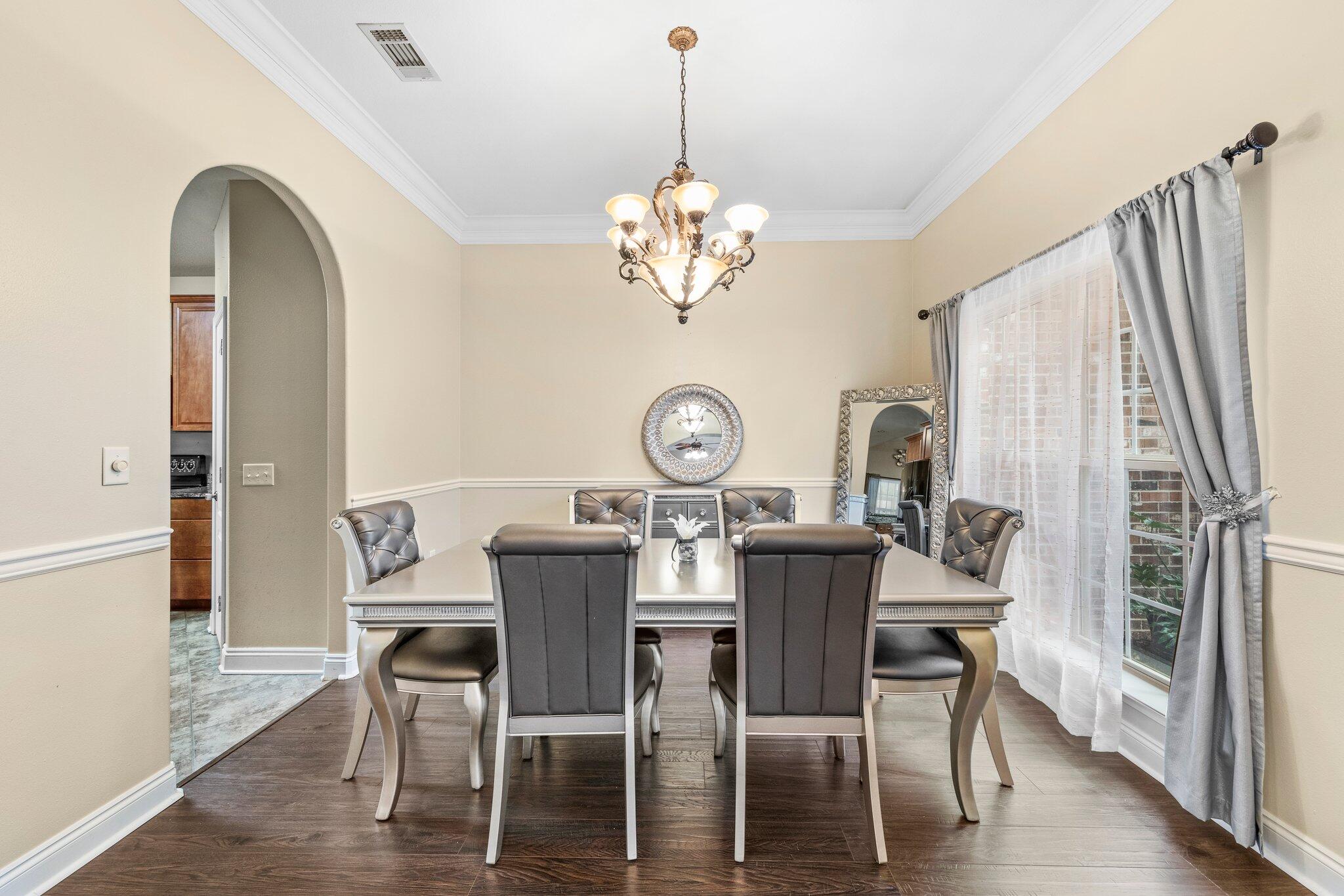901 Shoal River Drive Crestview, FL 32539 - Photo 15 of 56 a view of a dining room with furniture a chandelier and wooden floor