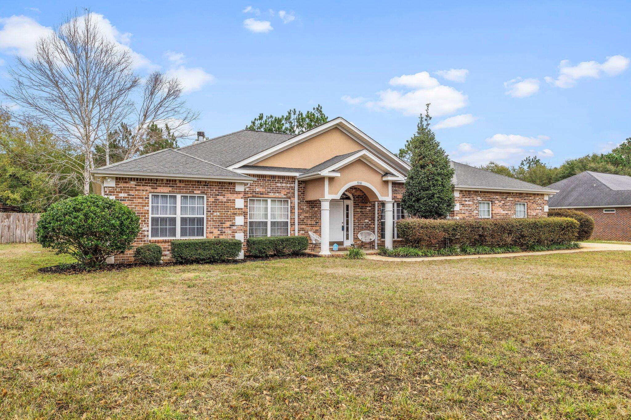 901 Shoal River Drive Crestview, FL 32539 - Photo 2 of 56 a front view of a house with a garden and yard