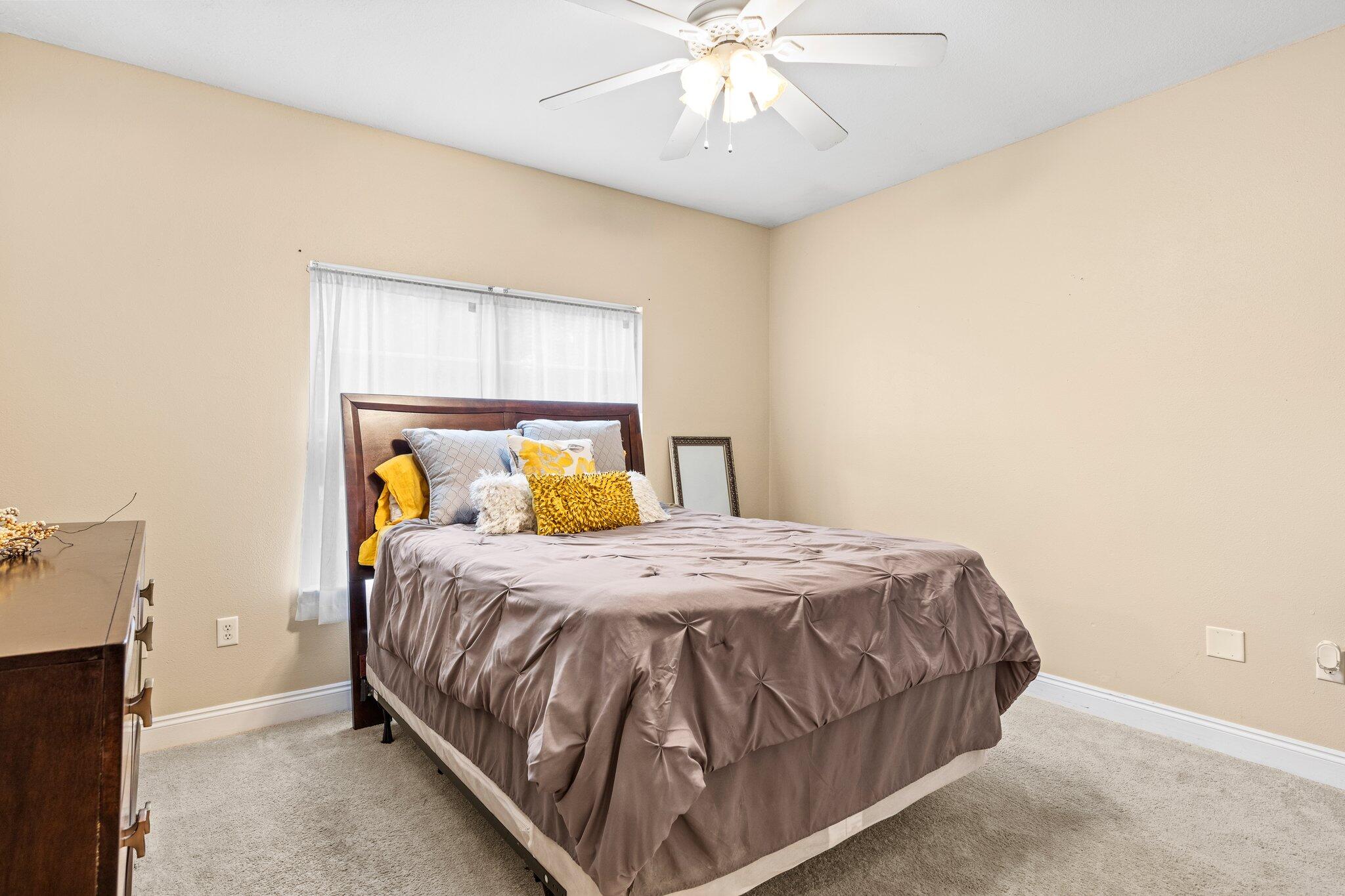901 Shoal River Drive Crestview, FL 32539 - Photo 26 of 56 a bedroom with a bed and a chandelier