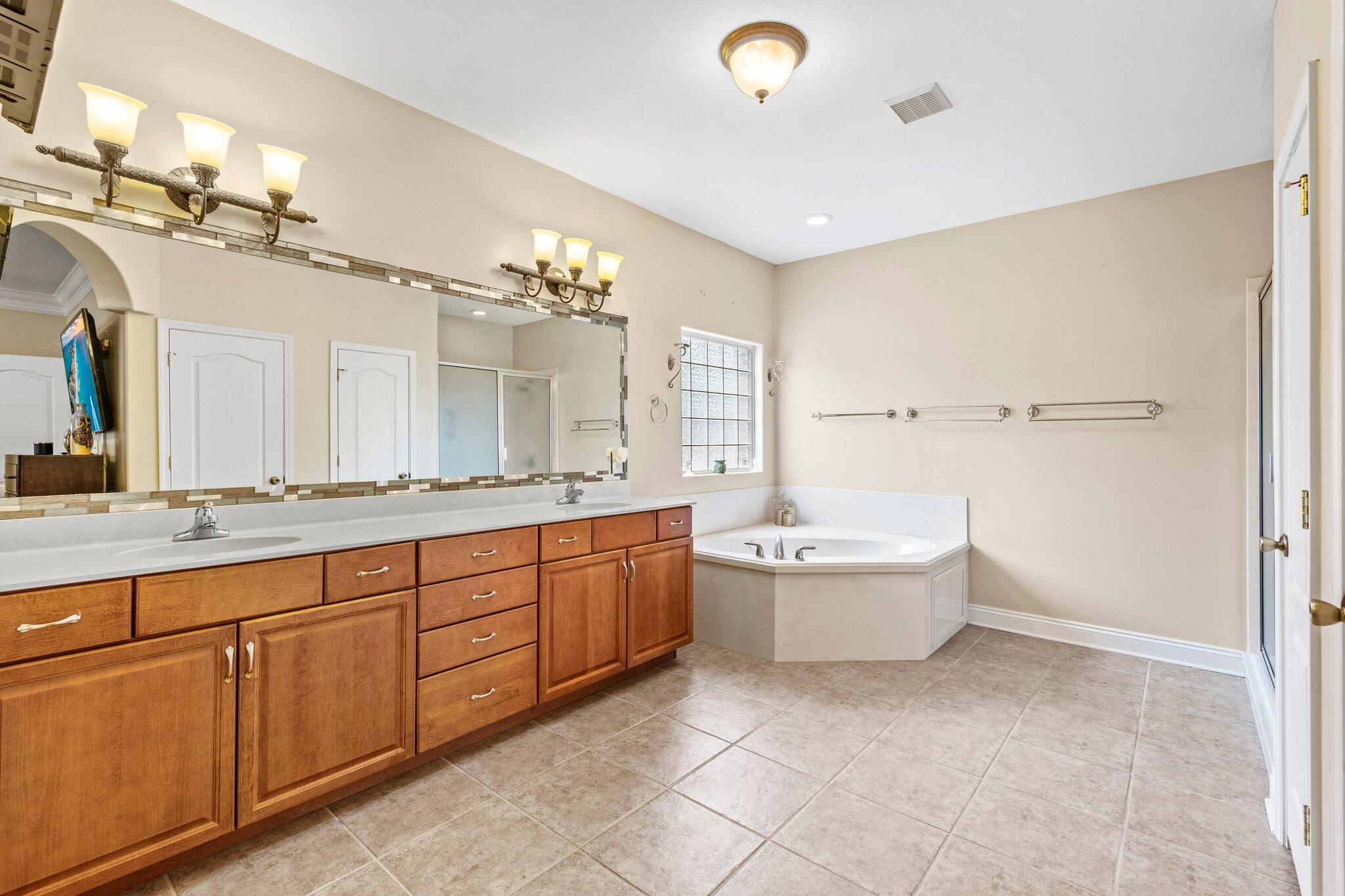 901 Shoal River Drive Crestview, FL 32539 - Photo 36 of 56 a spacious bathroom with a granite countertop sink a toilet mirror and bathtub