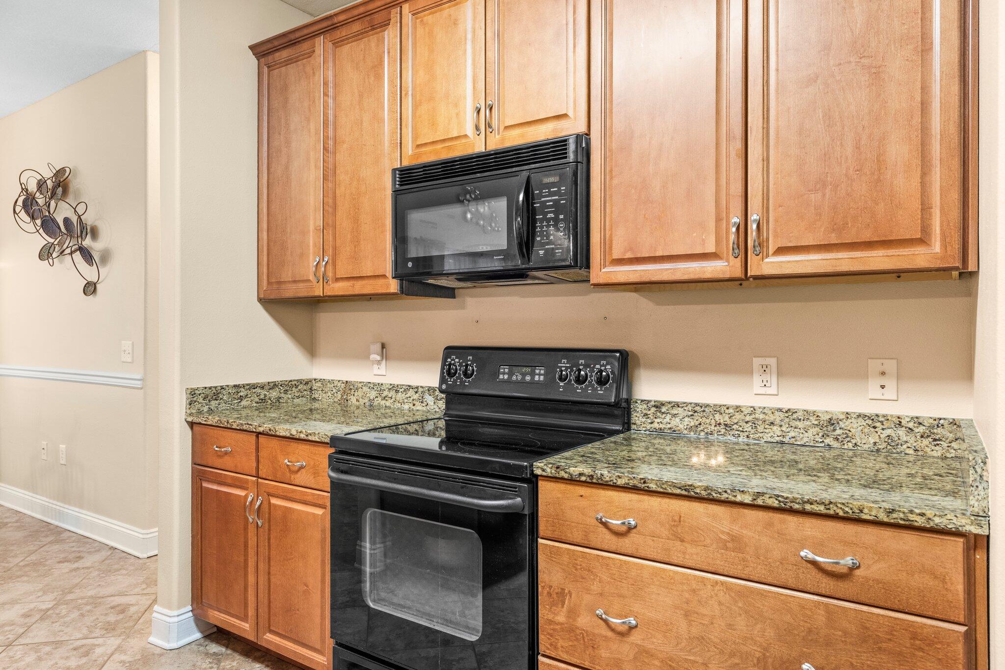 901 Shoal River Drive Crestview, FL 32539 - Photo 46 of 56 a kitchen with granite countertop a stove top oven cabinetry a sink and a window