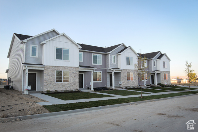 Townhome / multi-family property featuring central AC and a lawn