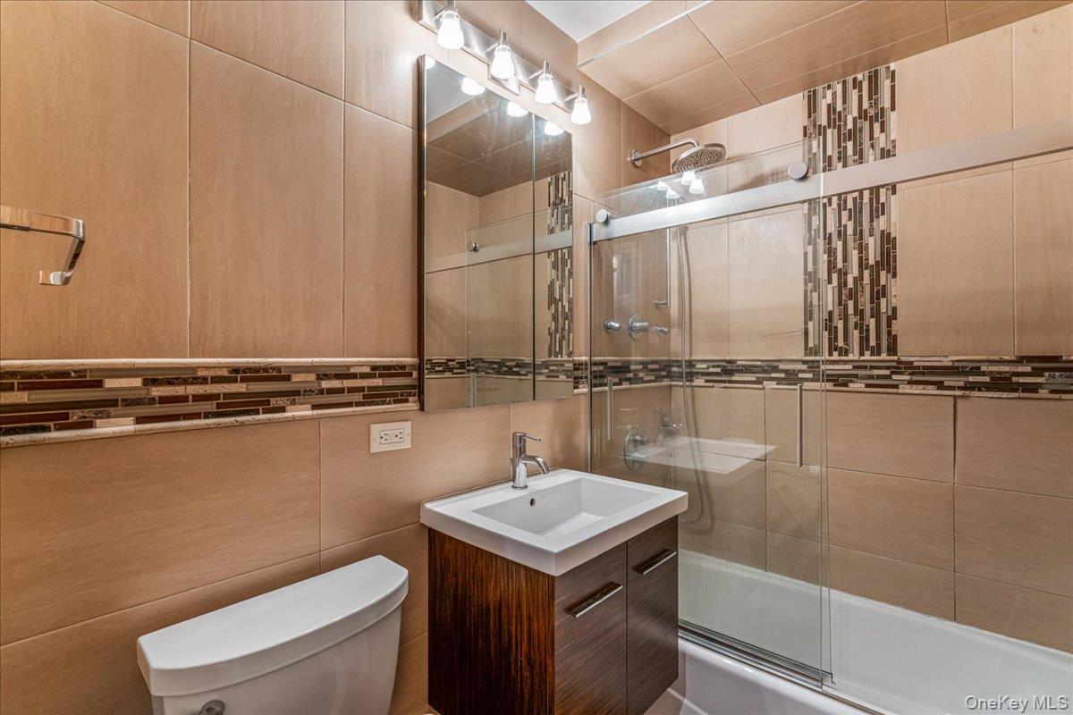 17-85 215th Street, Unit 9L Queens, NY 11360 - Photo 12 of 35 a bathroom with a sink a toilet and shower