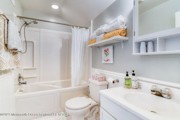 a bathroom with a sink a toilet and a shower curtain