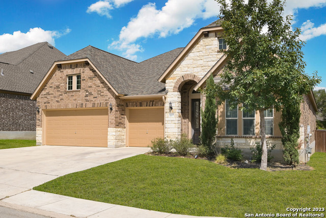 a front view of a house with a garden and yard
