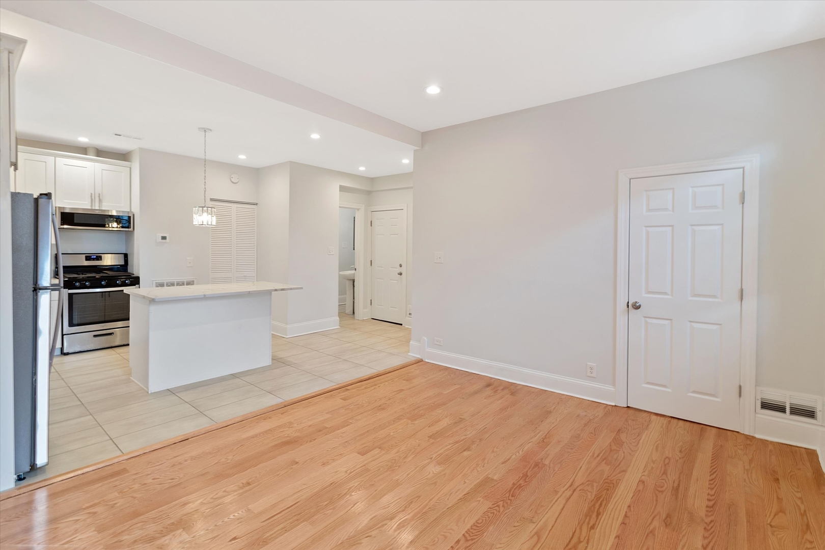 1729 South Halsted Street, Unit 2 Chicago, IL 60608 - Photo 5 of 14 a view of a kitchen with kitchen island white cabinets and stainless steel appliances