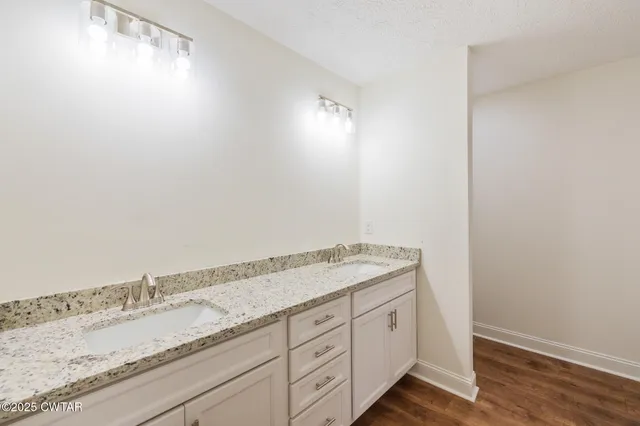 a spacious bathroom with a granite countertop sink and a mirror