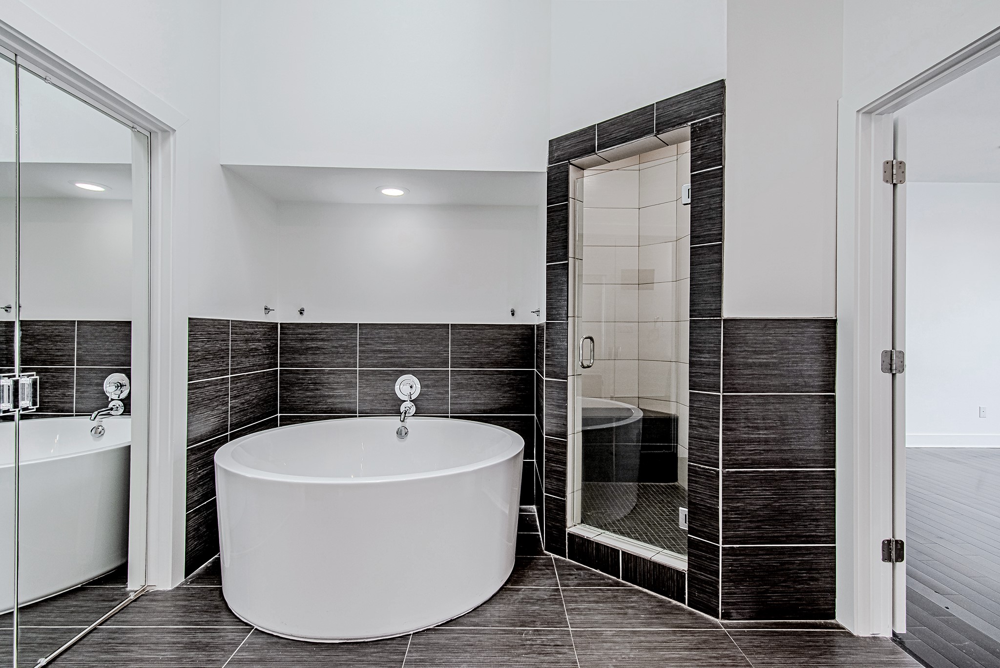2025 Colquitt Street, Unit E Houston, TX 77098 - Photo 20 of 29 Spa-inspired bathroom featuring a freestanding soaking tub and glass-enclosed shower.