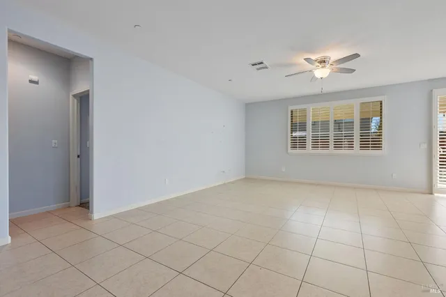an empty room with fan and windows