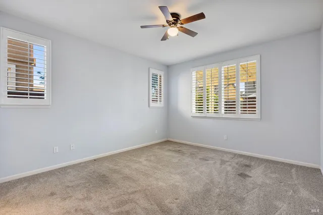 an empty room with windows and cabinet