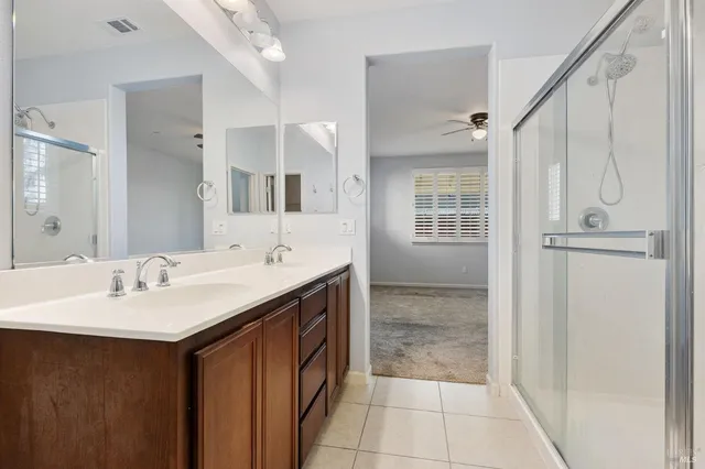a bathroom with a granite countertop sink a mirror and a shower