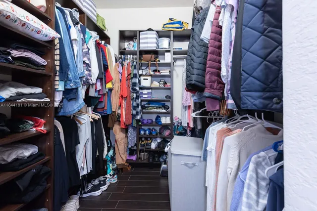 a view of walk in closet with clothes and shoes