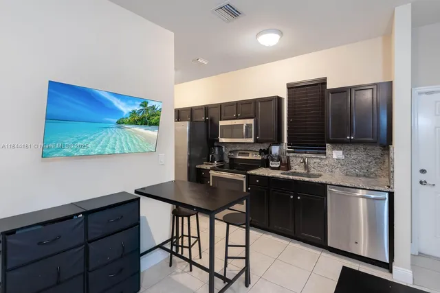 a kitchen with stainless steel appliances granite countertop a stove a sink and a refrigerator