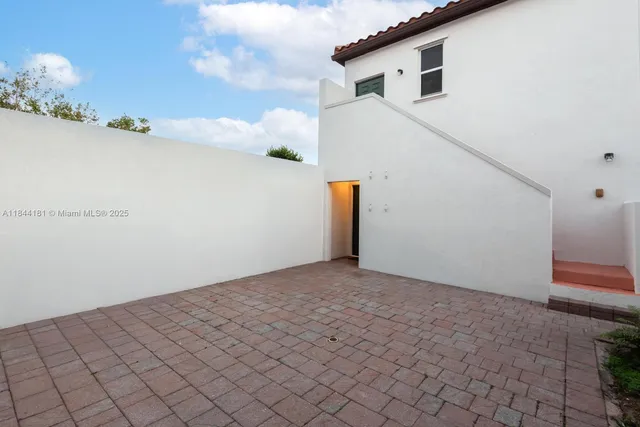 a view of a white house with a yard