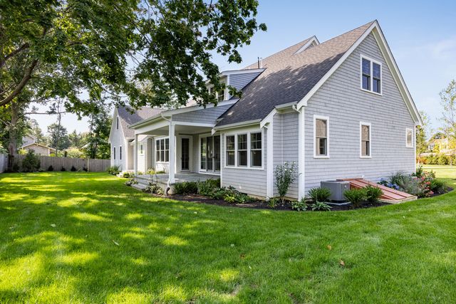 a front view of a house with a garden and yard