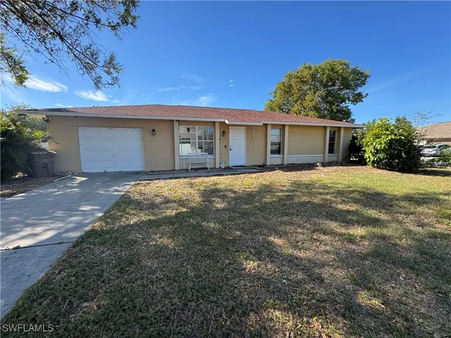a view of a house with a yard and potted plants