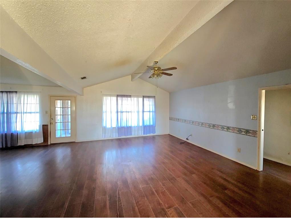 810 Cody Road Ennis, TX 75119 - Photo 15 of 31 a view of an empty room with wooden floor and a window