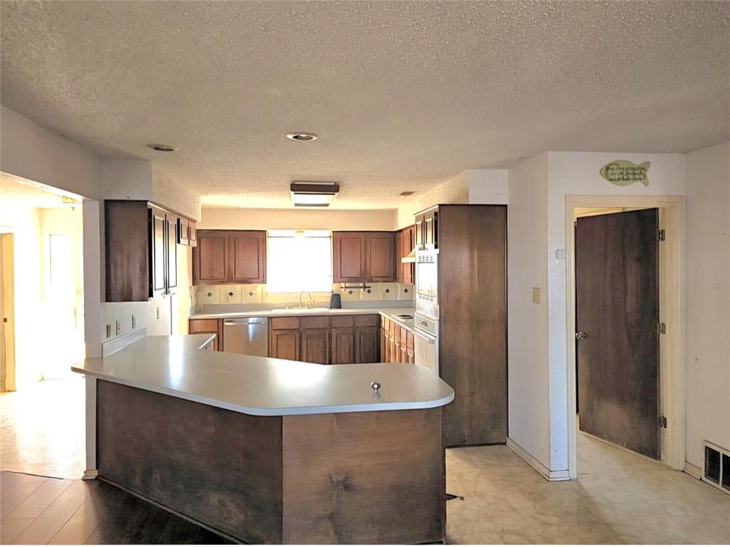 810 Cody Road Ennis, TX 75119 - Photo 17 of 31 a kitchen with stainless steel appliances granite countertop a lot of refrigerator