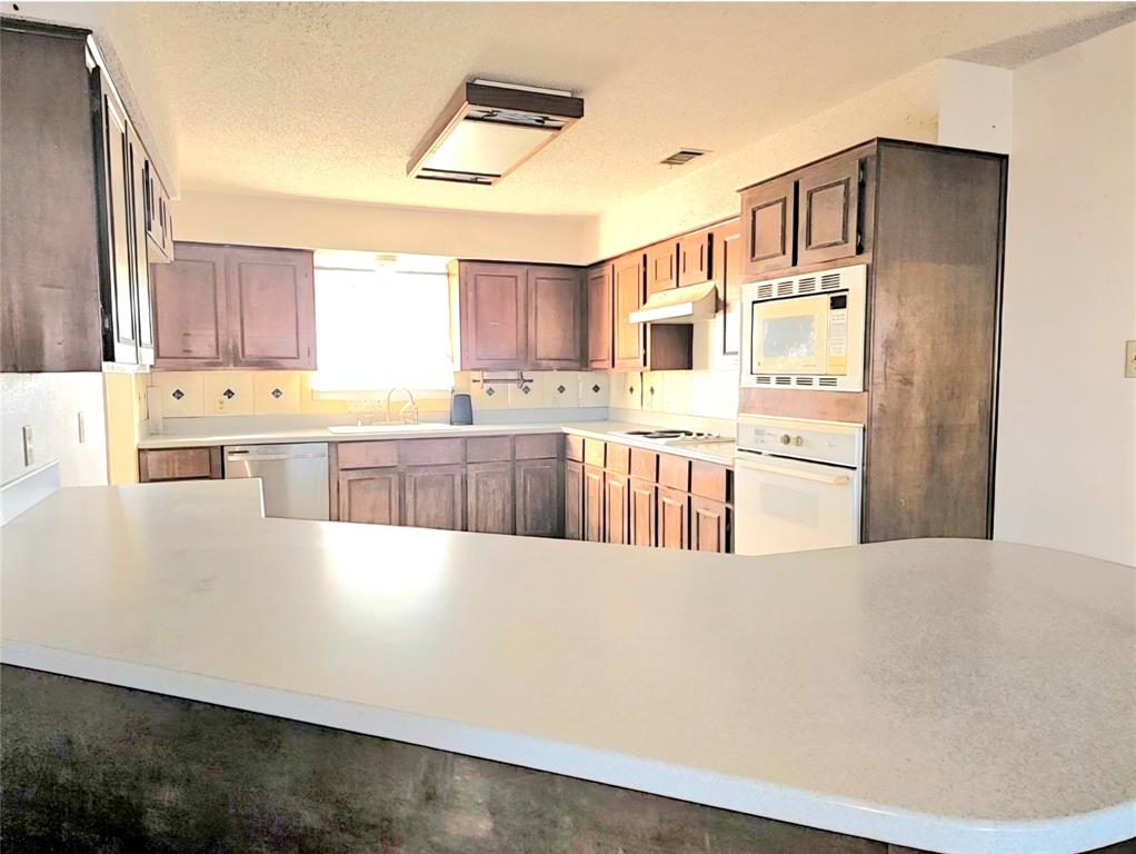 810 Cody Road Ennis, TX 75119 - Photo 23 of 31 a large kitchen with stainless steel appliances a stove a sink a refrigerator and cabinets