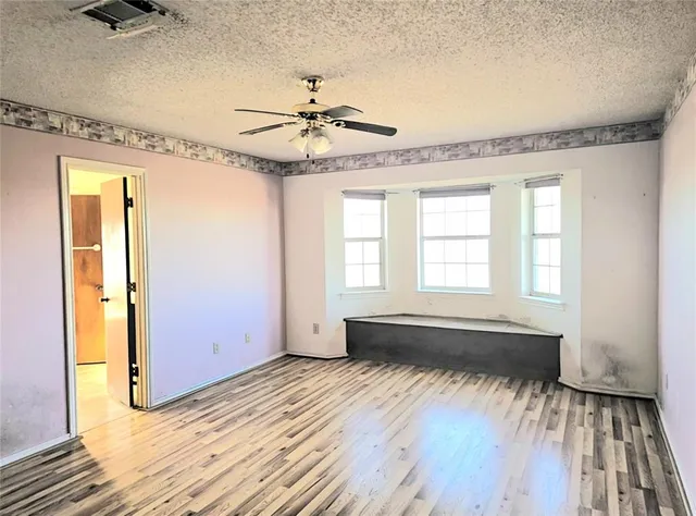 a view of a room with wooden floor and a ceiling fan