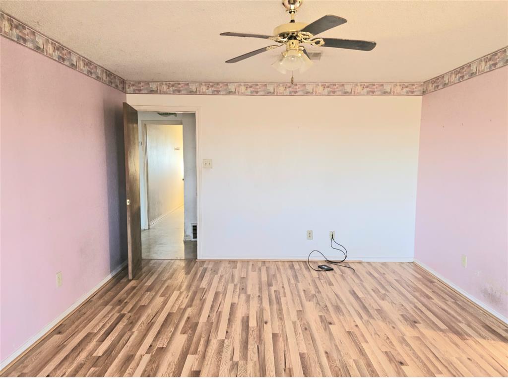 810 Cody Road Ennis, TX 75119 - Photo 26 of 31 a view of a room with wooden floor and a ceiling fan