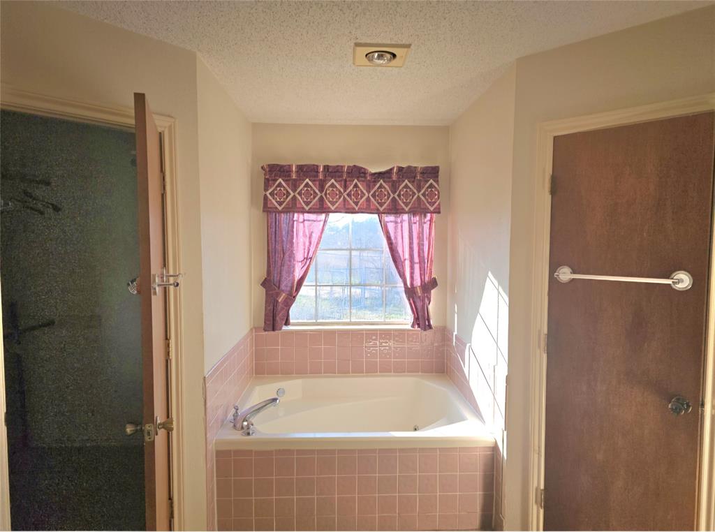810 Cody Road Ennis, TX 75119 - Photo 27 of 31 a bathroom with a bathtub and a shower