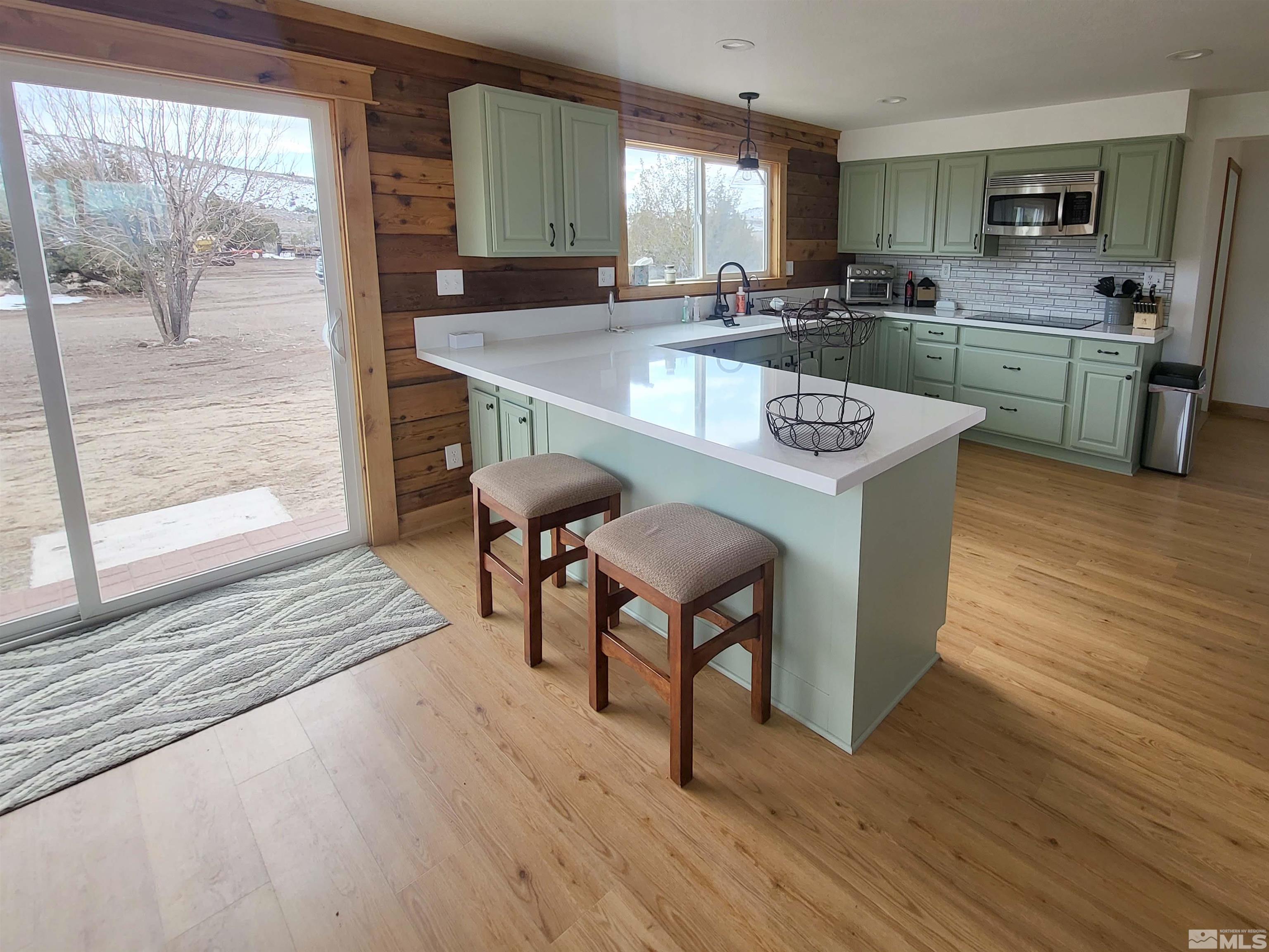 2700 Wilcox Ranch Road Reno, NV 89510 - Photo 9 of 33 a kitchen with stainless steel appliances granite countertop a kitchen island hardwood floor sink stove dining table and chairs