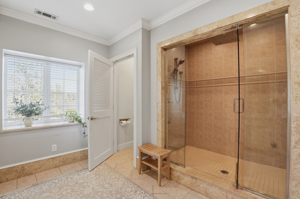 183 Whiting Street Hanover, MA 02339 - Photo 22 of 42 a bathroom with a glass shower door and a window