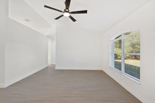 an empty room with fan and windows