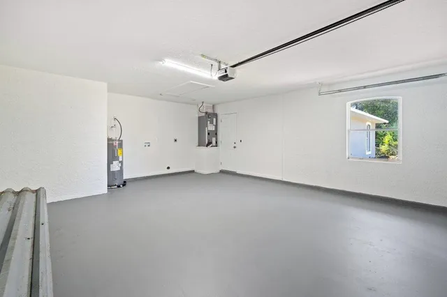 an empty room with a ceiling fan and windows