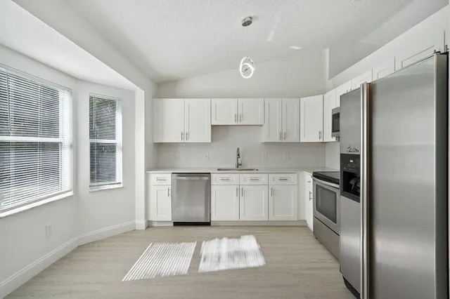 a kitchen with a refrigerator stove top oven and sink