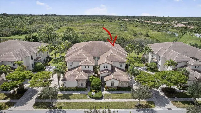 an aerial view of residential houses with outdoor space and trees