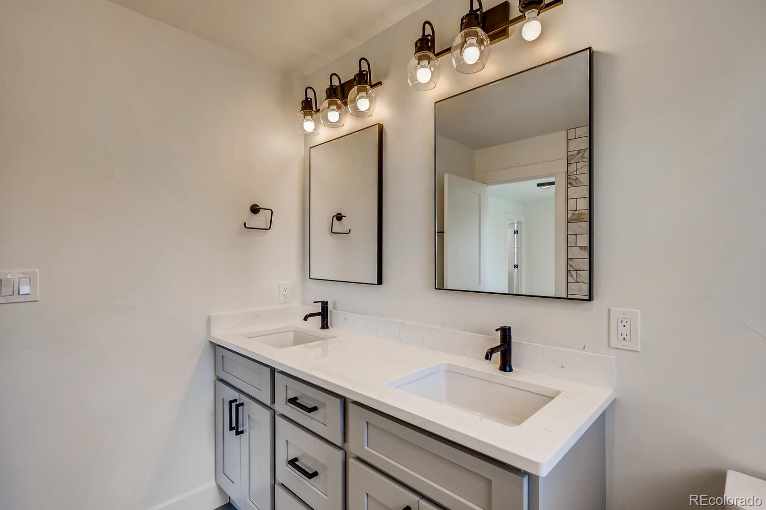 949 Raleigh Street, Unit 2 Denver, CO 80204 - Photo 22 of 26 a bathroom with a sink vanity and mirror
