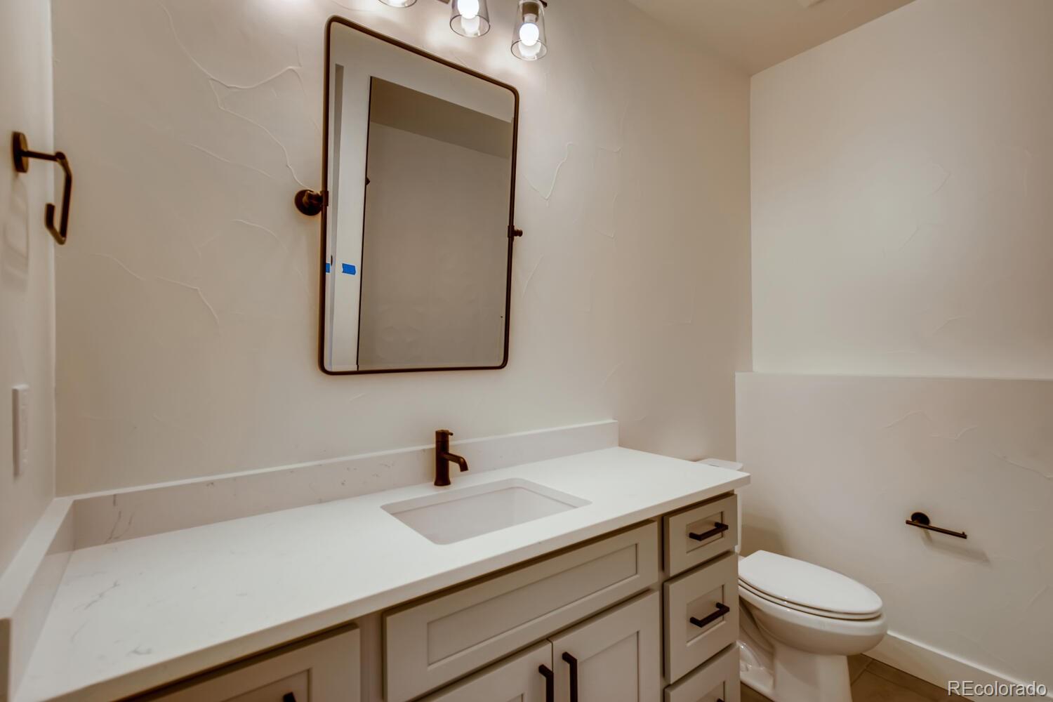 949 Raleigh Street, Unit 2 Denver, CO 80204 - Photo 8 of 26 a bathroom with a toilet sink and mirror