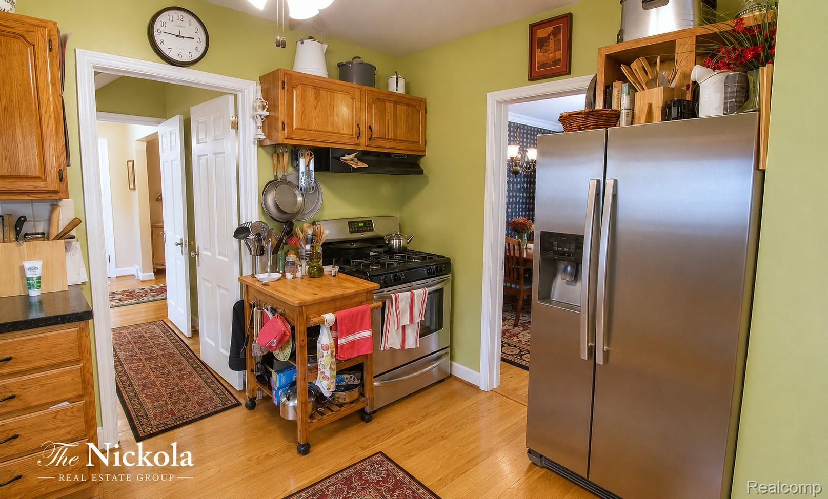515 Barrington Road Detroit, MI 48215 - Photo 27 of 27 Kitchen featuring stainless steel appliances, light wood-type flooring, wood finish cabinets, and range hood