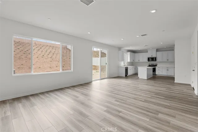 a view of empty room with wooden floor and windows