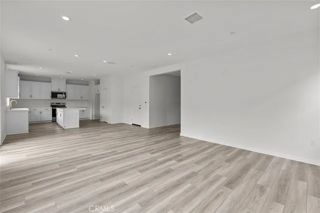 a view of a kitchen with wooden floor and a refrigerator