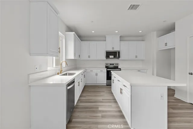 a kitchen with white cabinets appliances and sink