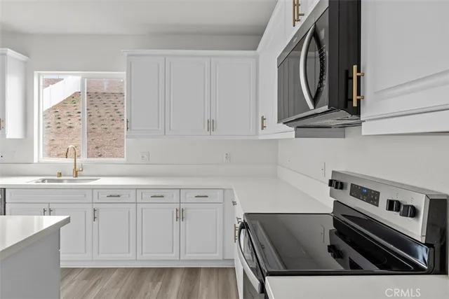 a kitchen with stainless steel appliances granite countertop a sink and cabinets