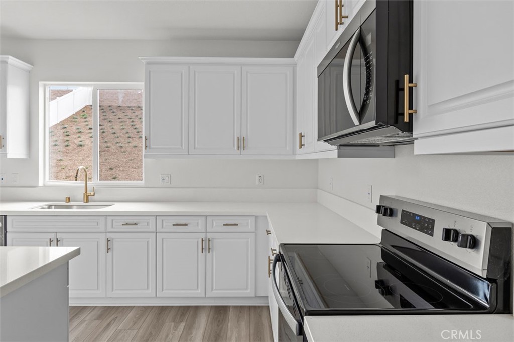 27353 Dunite Drive Perris, CA 92571 - Photo 7 of 18 a kitchen with stainless steel appliances granite countertop a sink and cabinets