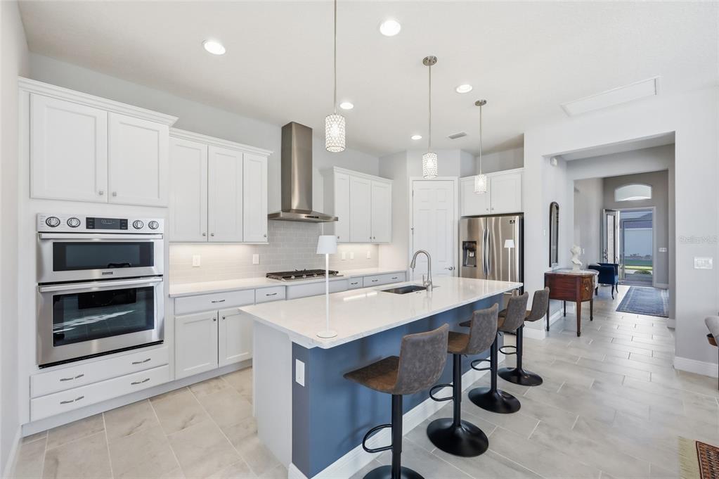 2154 Wallingford Loop Mount Mount Dora, FL 32757 - Photo 15 of 52 a kitchen with a stove a refrigerator and chairs