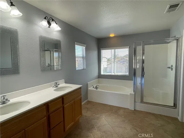 a spacious bathroom with a bathtub sink double vanity and mirror