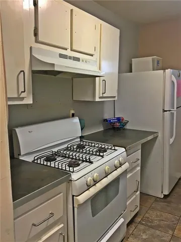 a white stove top oven sitting inside of a kitchen