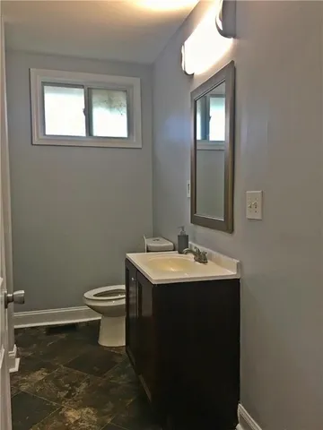 a bathroom with a toilet sink and mirror