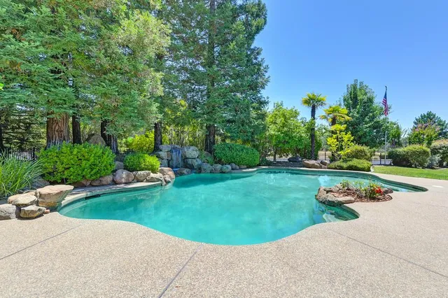 a front view of a house with swimming pool garden and patio